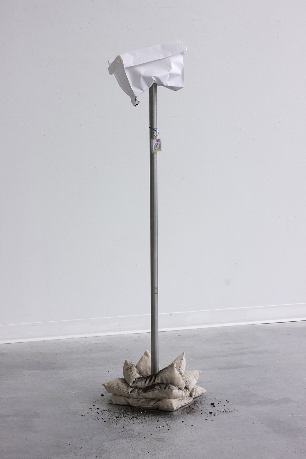 <i>Pole</i><br> Steel, paper bag, pillows, soil, keychain, digital photograph, 60 x 12 x 12 in, 2021.